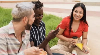 Diverse people having fun eating take away food outdoor in the city - Focus on Asian girl face