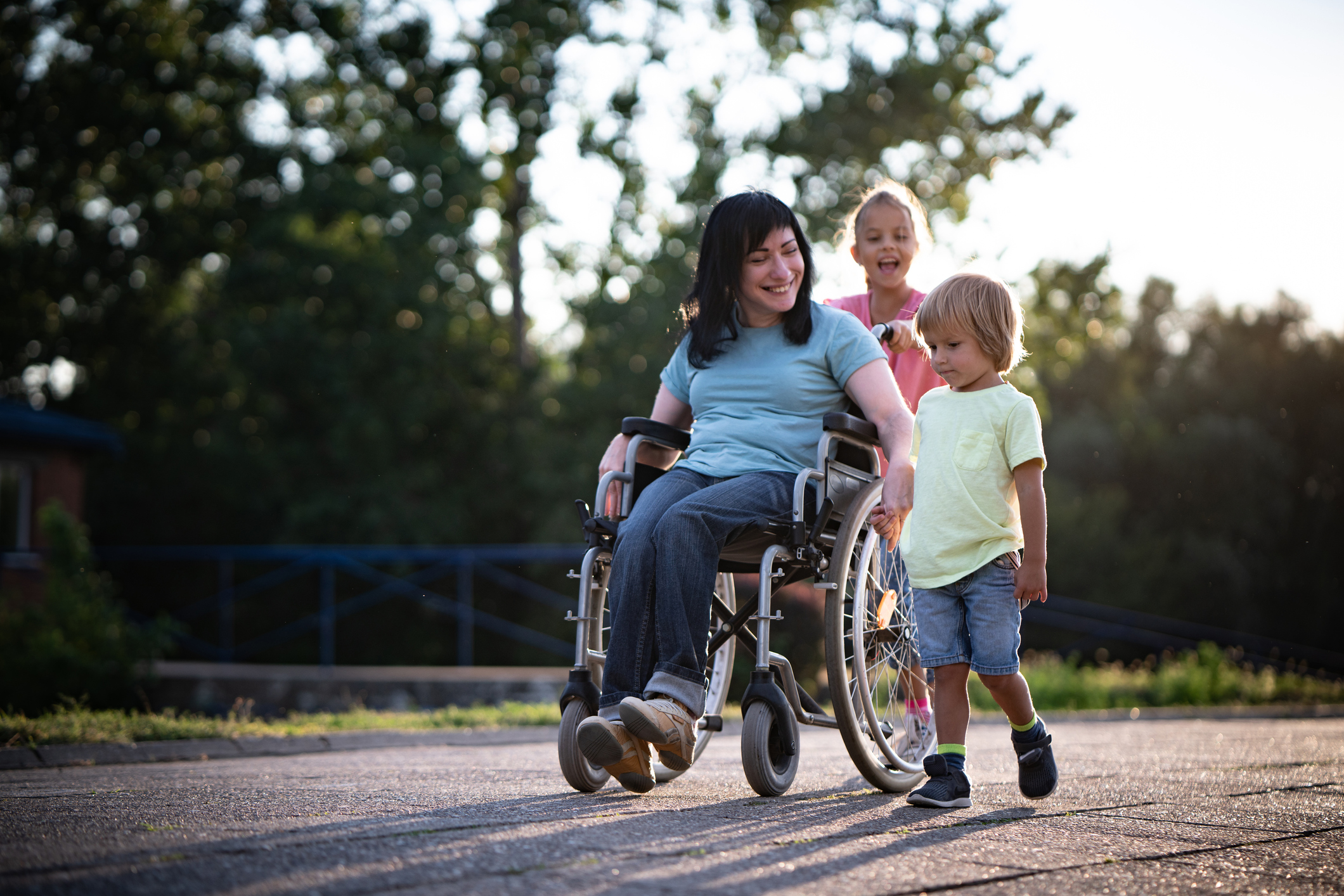 Mother in wheelchair whit her children spending time outdoors
