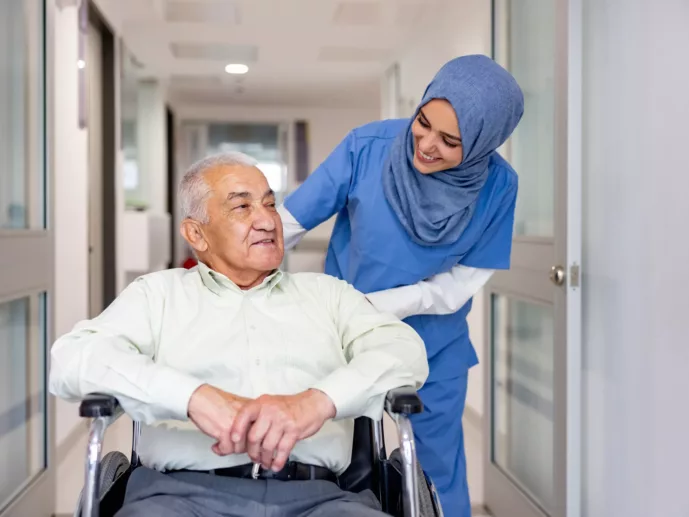 Muslim nurse taking care of a senior patient in a wheelchair